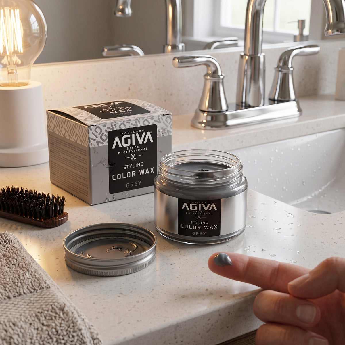 AGIVA Styling Color Wax Grey i åben glaskrukke på badeværelsesbord med finger dyppet i grå voks.