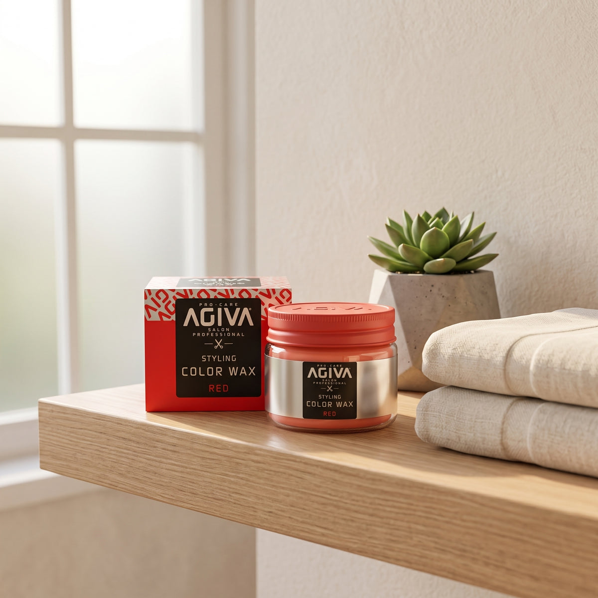 AGIVA Styling Color Wax Red i rød emballage ved siden af åben glaskrukke på træhylde med sukkulent og håndklæder.