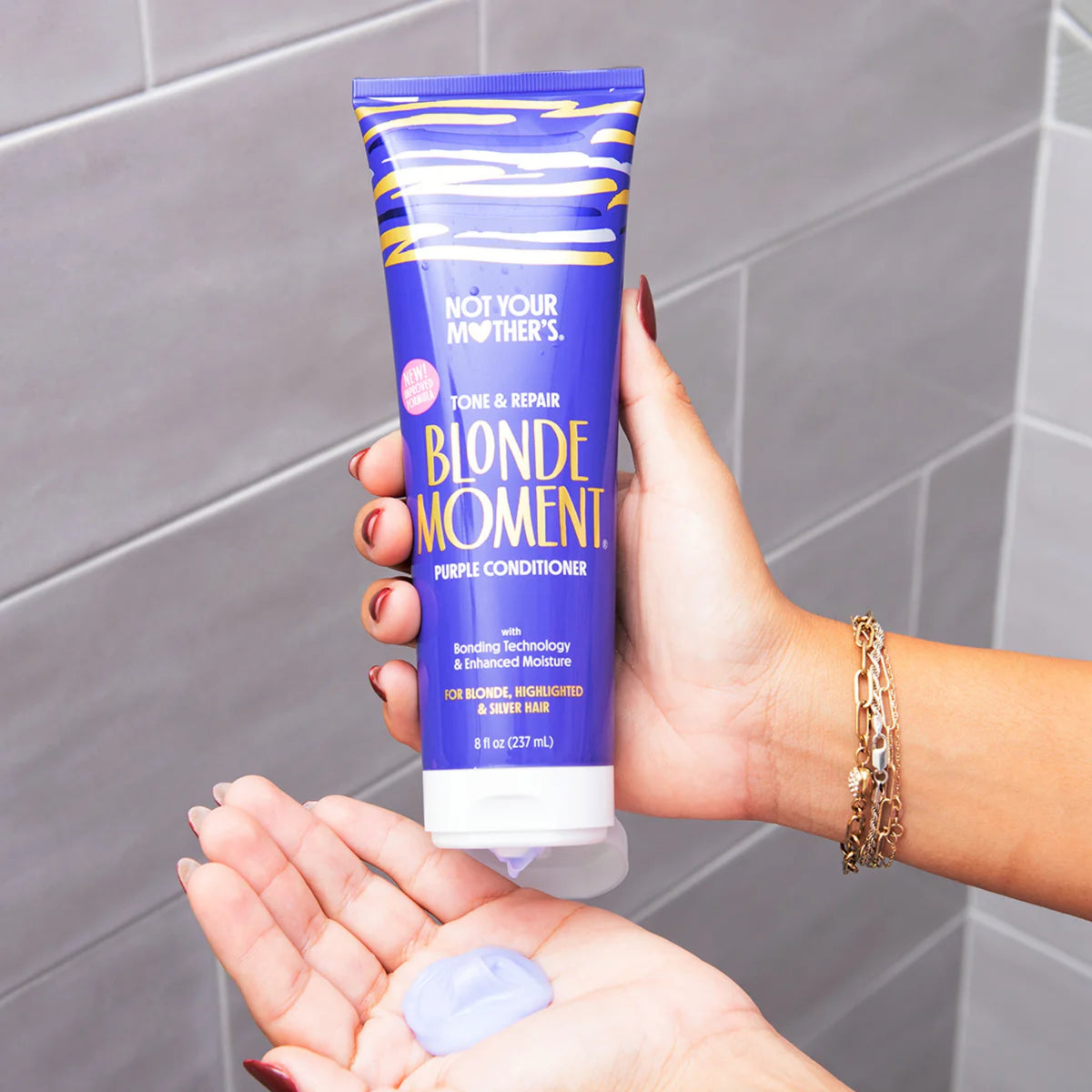 Not Your Mother's Blonde Moment lilla conditioner i hånden med en klat produkt i den anden hånd.