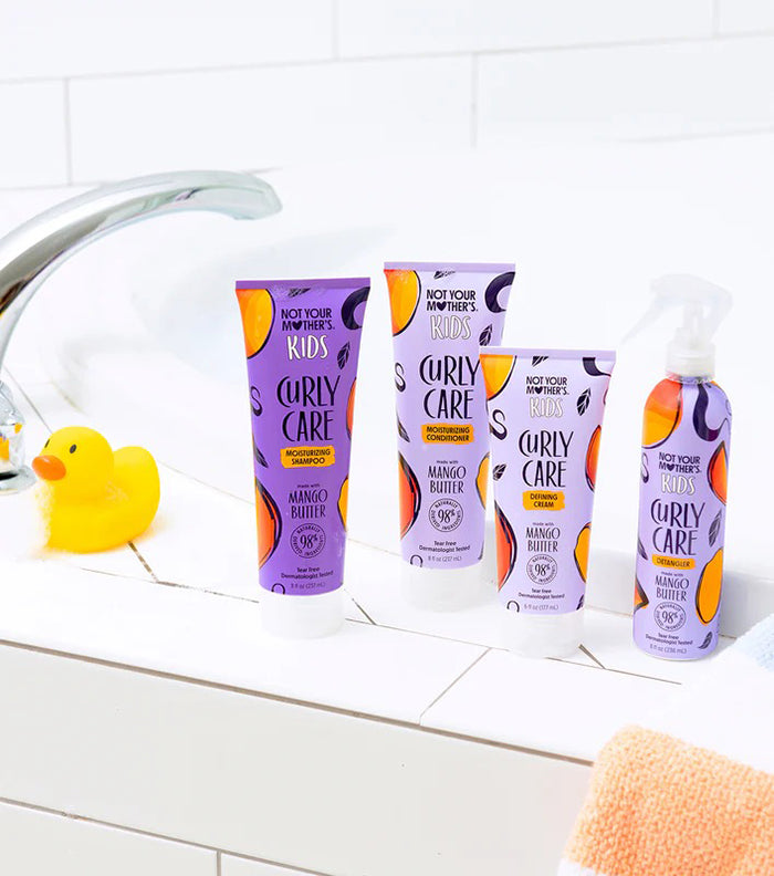 Not Your Mother's Kids Curly Care Shampoo 237ml med mango butter står på badeværelseskant med farverige matchende produkter.